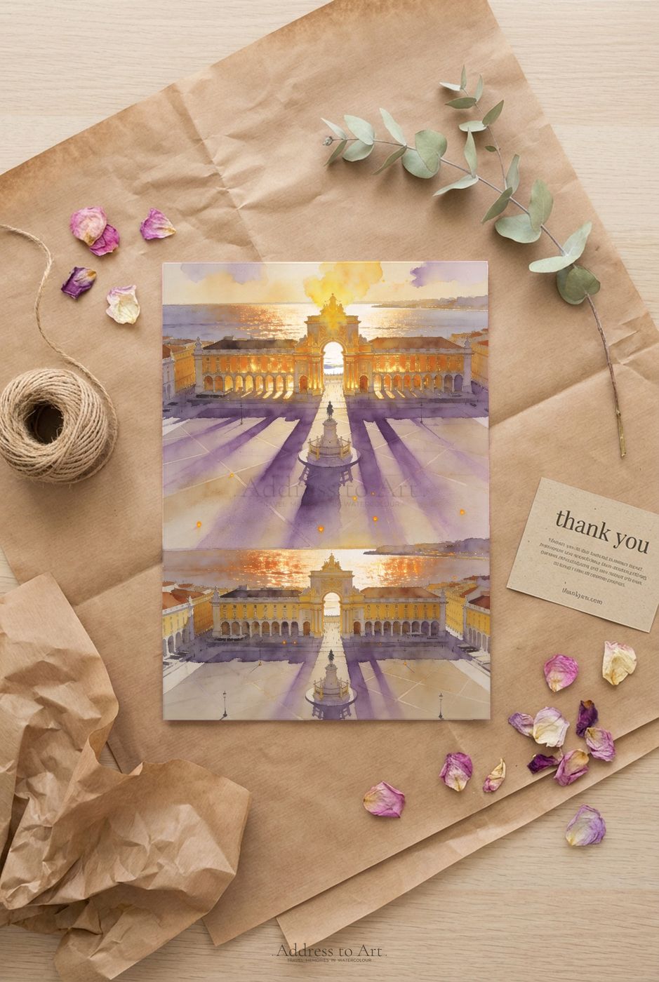 Lisbon watercolor print in gift packaging — acid-free tissue, kraft box, golden sunset over Praça do Comércio visible through the wrap