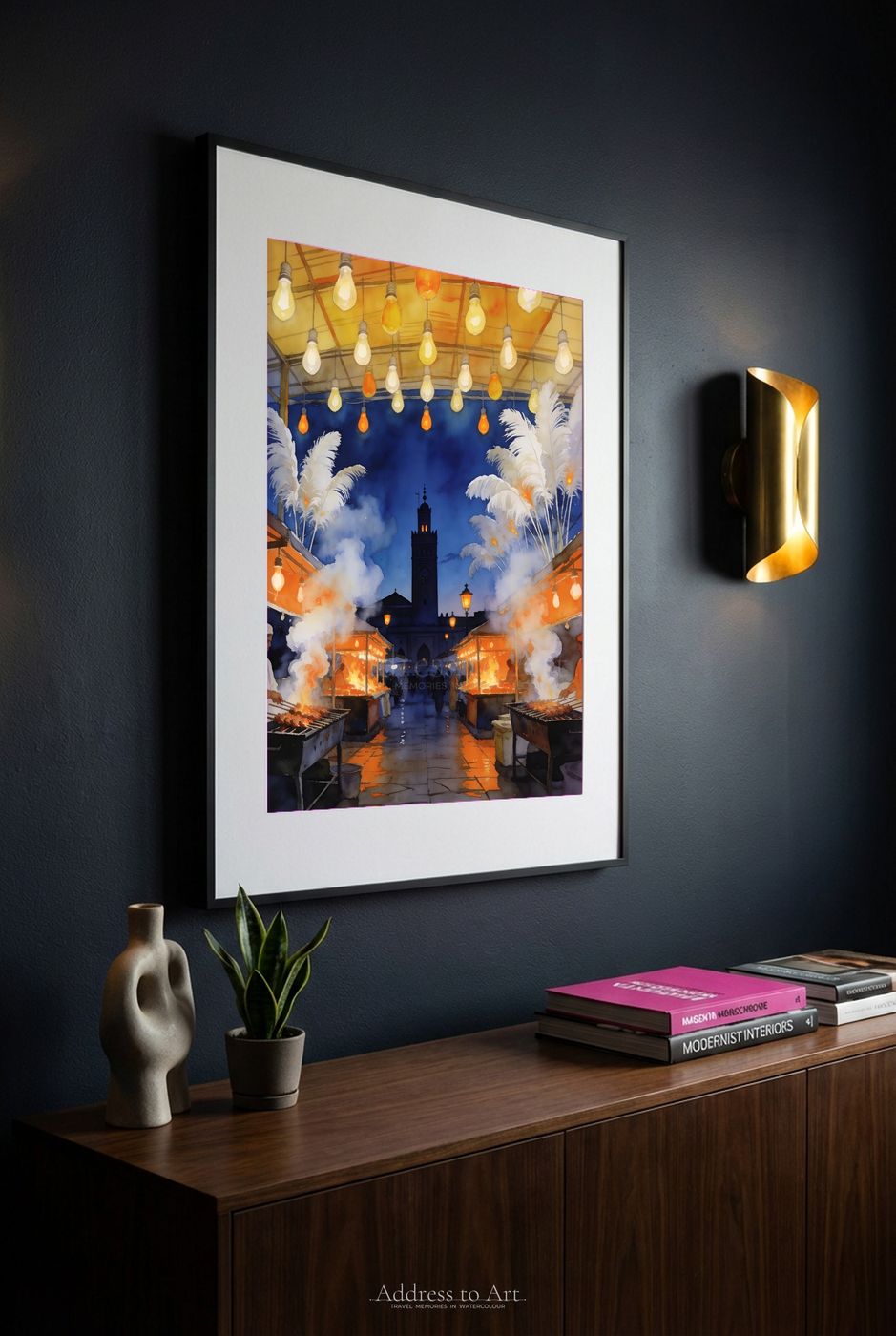 Marrakech market watercolor on a dark charcoal wall — lanterns and spice stalls glowing warm beside a brass lamp